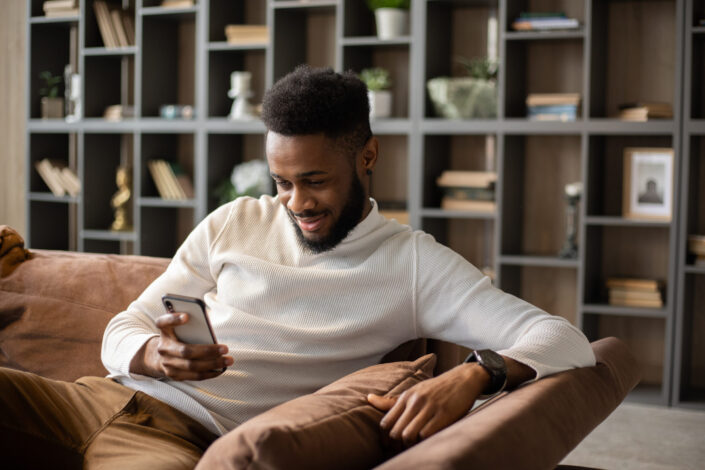 Smiling young man using his cellphone