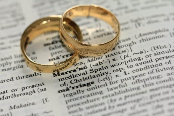 Gold wedding rings on a dictionary