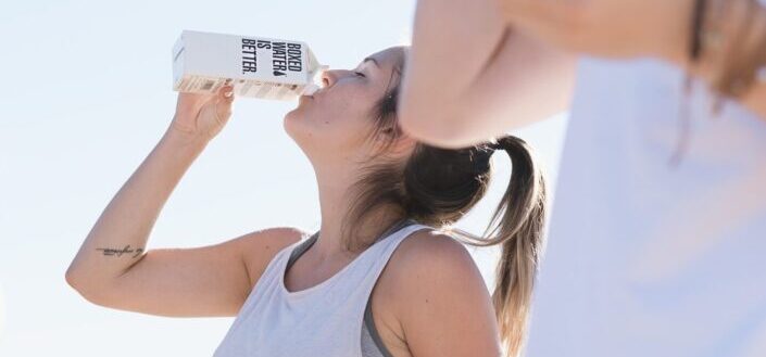 two women working out and drinking boxed water