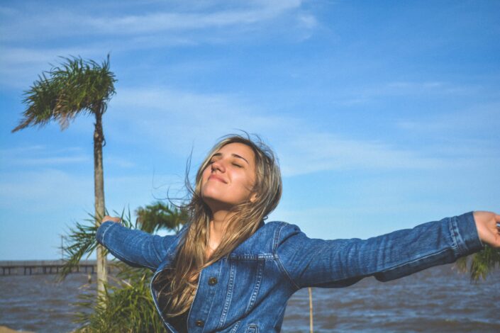 Woman Raising Her Arms to Enjoy the Wind and Sun