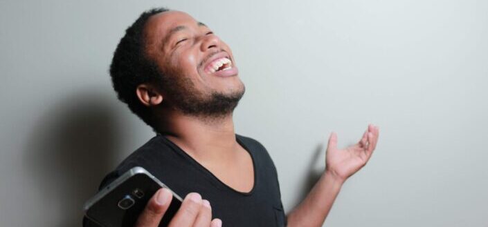 Man laughing while holding his phone