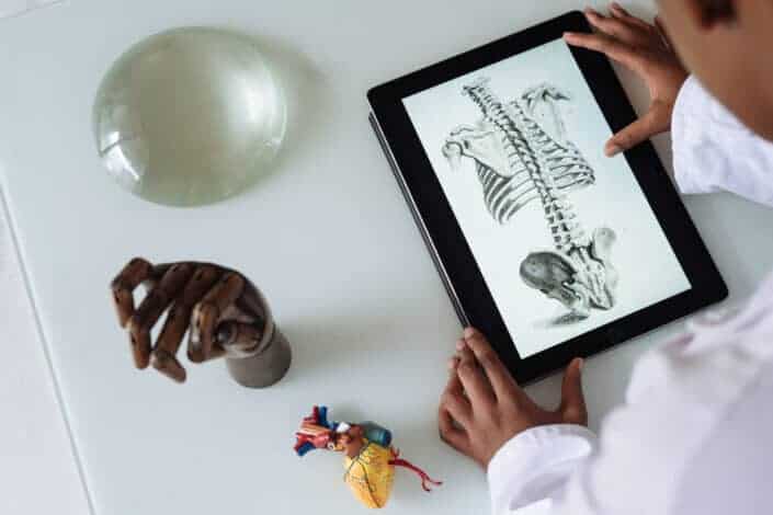 A doctor looking at a skeleton photo on his tablet