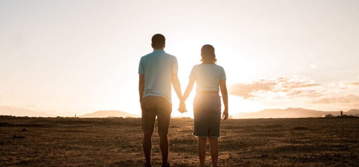 Man and Woman Holding Hands While Watching the Sunset