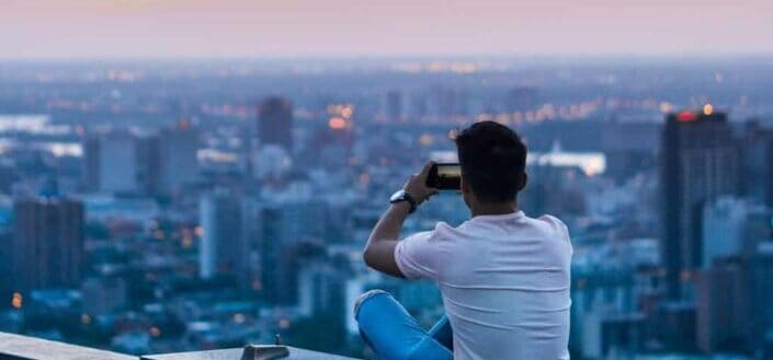 Man Taking a Picture of the Skyline With His Phone