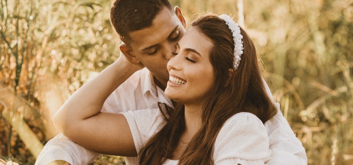 Man kissing a woman while sitting 