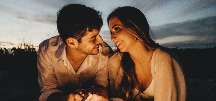 Guy staring at his girlfriend while holding hands