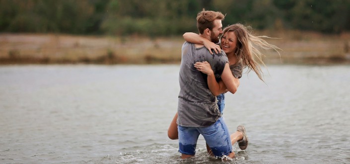 Man hugging woman while standing in lake