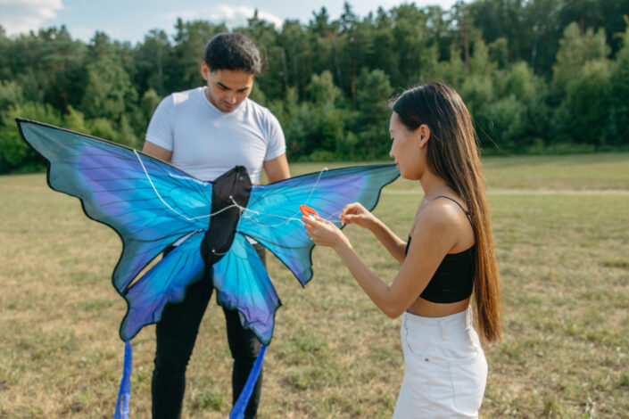 A man and woman fixing a butterfly kite