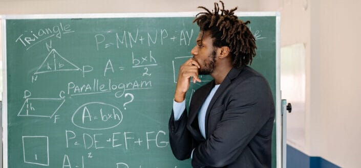 a-teacher-in-black-coat-contemplating-by-the-blackboard-stockpack-pexels