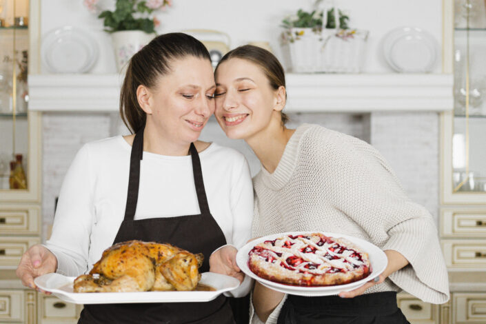 Affectionate mother and daughter holding a plate of fresh cooked meals
