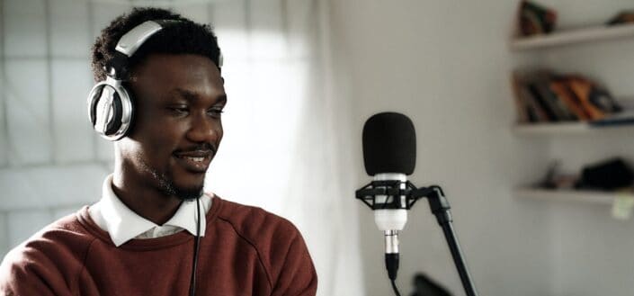 african-male-voice-over-artist-recording-a-voice-over-script-with-a-condenser-and-pioneer-exclusive-headphones-stockpack-unsplash