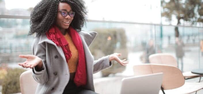 Cheerful surprised woman sitting with laptop