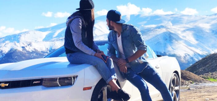 Couple near white chevrolet coupe