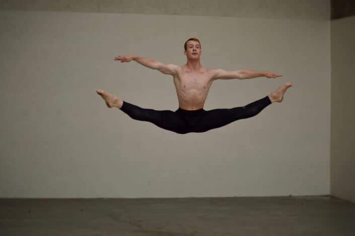 Flexible male dancer jumping in studio