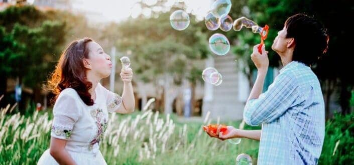 girl-and-man-blowing-bubbles-near-grass-at-daytime-stockpack-unsplash