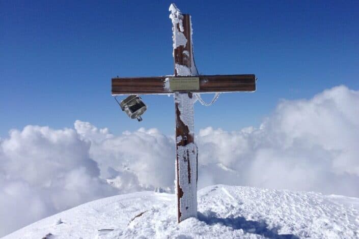 Grave cross on snowy hilltop
