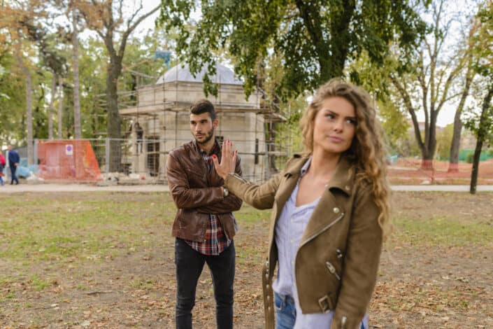 Man and woman in brown leather coat standing on brown soil