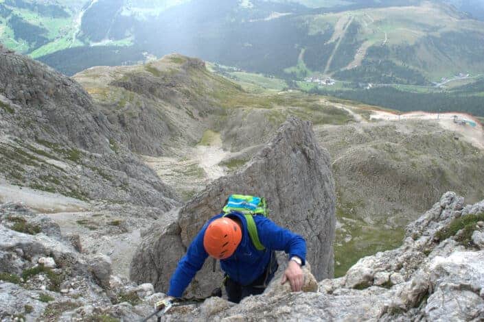 Man in Blue Jacket Climbing a Mountain