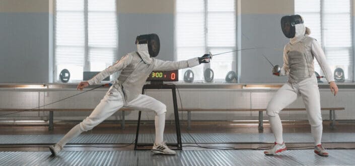 People Practicing Fencing in a Studio