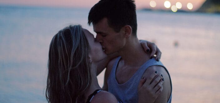 Partner kissing on beach