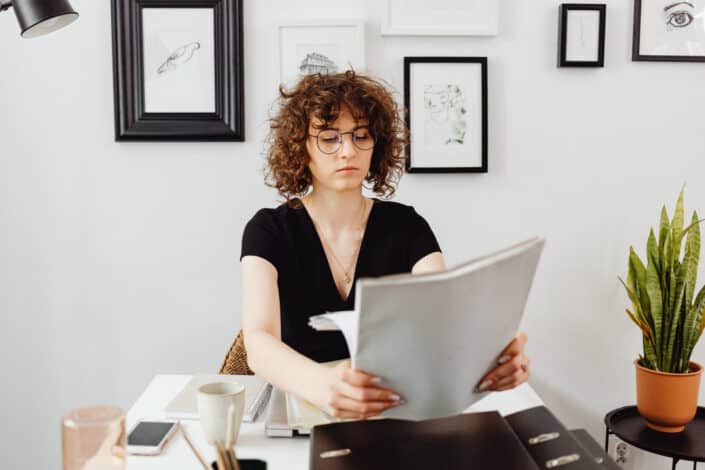 woman-in-black-shirt-holding-bunch-of-documents-stockpack-pexels