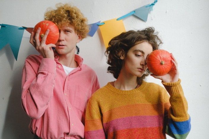 A man and woman holding a pumpkin