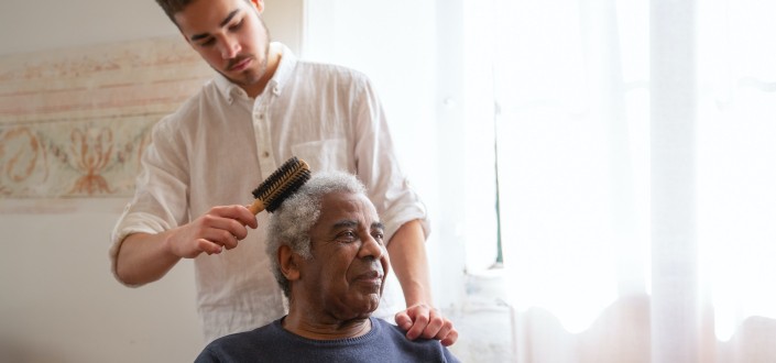 Barber combing a man's gray hair