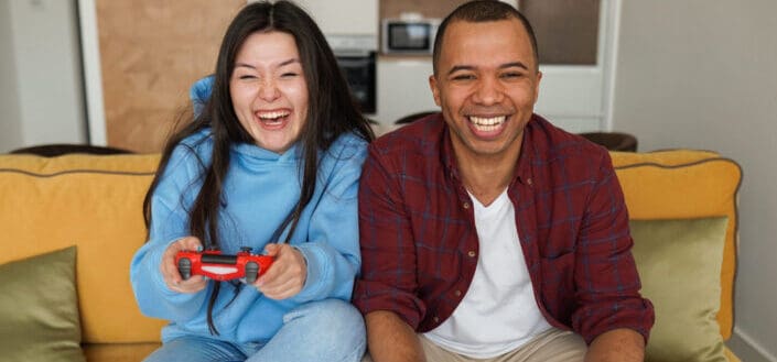 couple laughing as they play video game