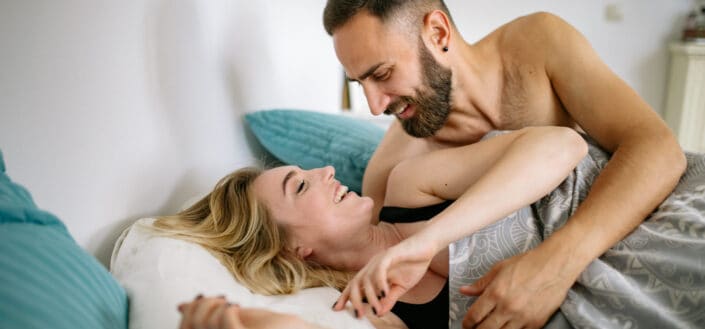 Couple lying in bed and smiling