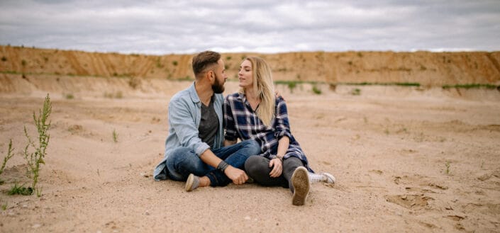 Couple sitting on sand in desert