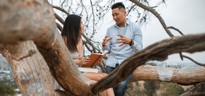 Couple Talking While Sitting on Tree Branch