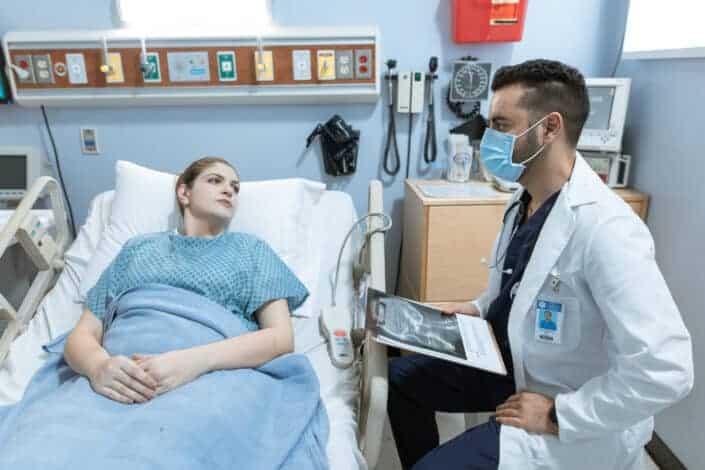 Doctor Talking to Patient on Bed