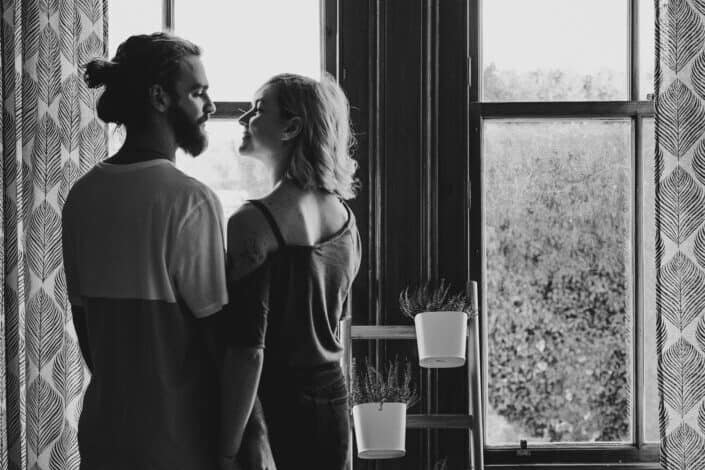 Couple looking at each other near a window