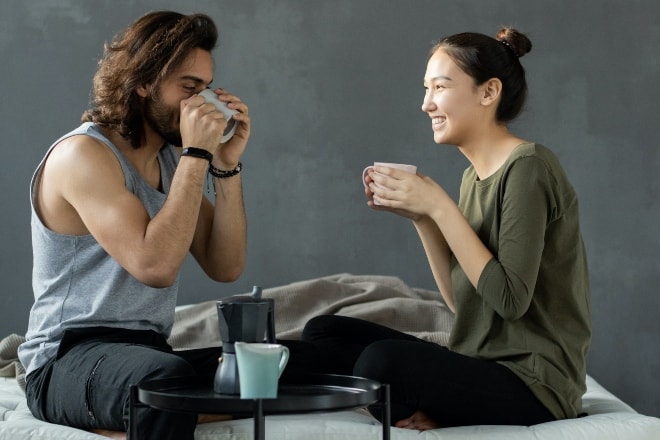 Ways to say good morning - man and woman sitting on the bed having coffee
