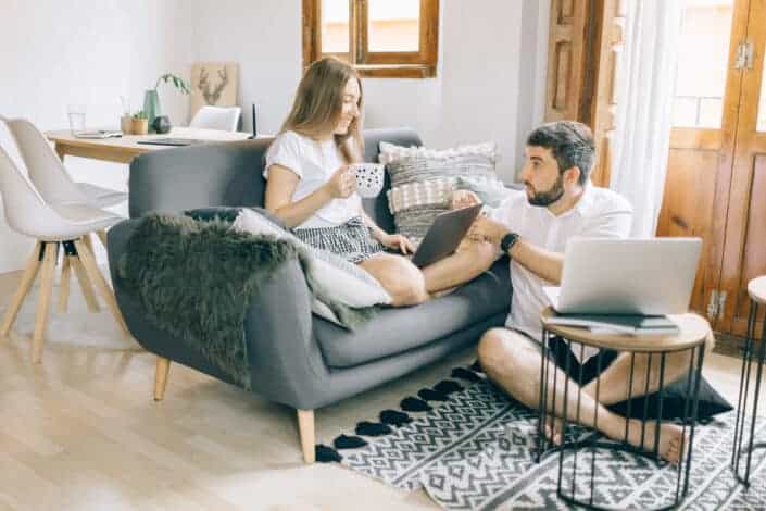 Man and woman talking while working in the living room