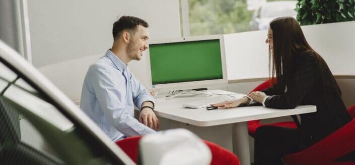 Two People Sitting at Table in Office 