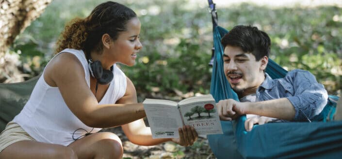 Couple reading a book in a forest