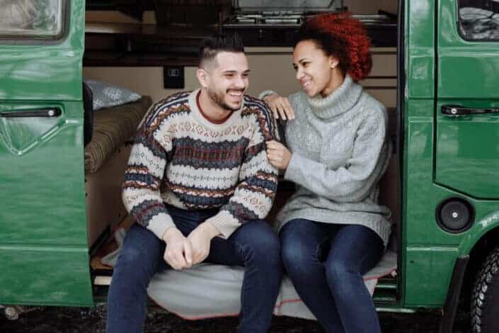 A couple happily sitting on car