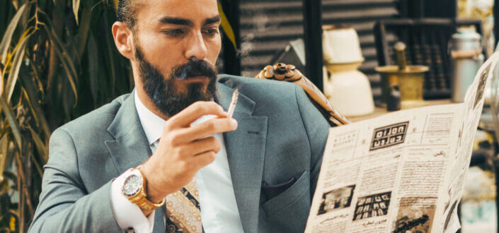 Stylish Man Reading Newspaper While Smoking