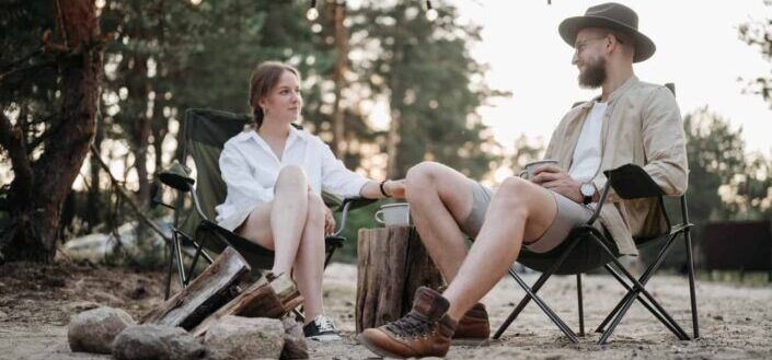 A couple sitting on folding chairs while having conversation