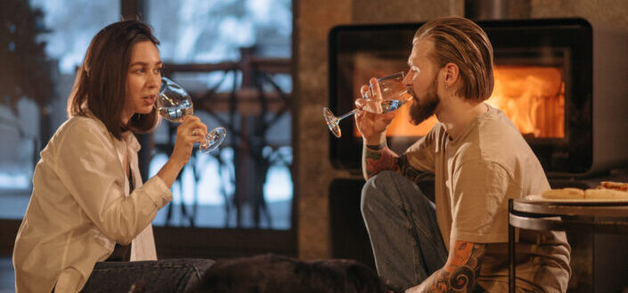Couple drinking wine near a fireplace