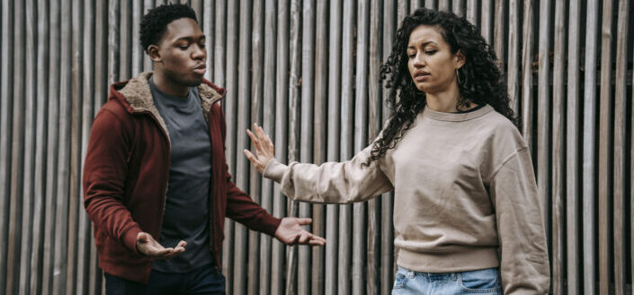 Expressive multiethnic couple having conflict on street