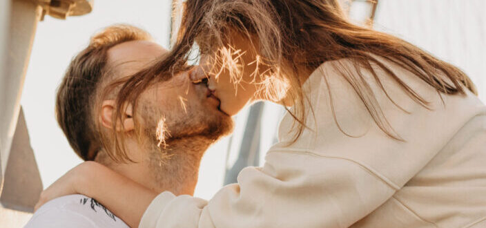 Romantic Couple Kissing on Street in Sunlight