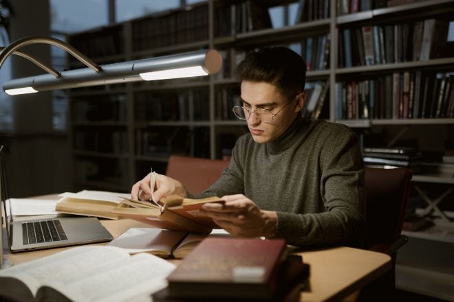 Man reading a book in library - sigma male quotes