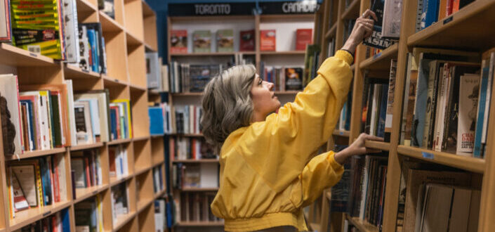 woman getting a book from one of a shelf in a library