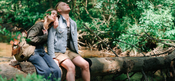 A Man and a Woman Sitting on a Wooden Log