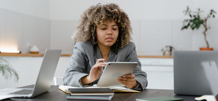 Woman in Gray Long Sleeves Browsing on the Ipad