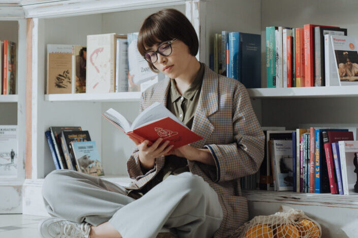 Woman lost in the world of what she is reading in a library