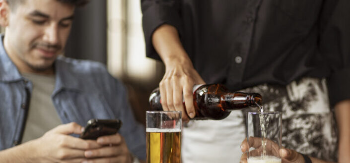 Waiter Pouring Beer Into the Glasses