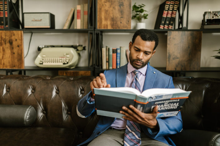 A man in corporate attire reading book